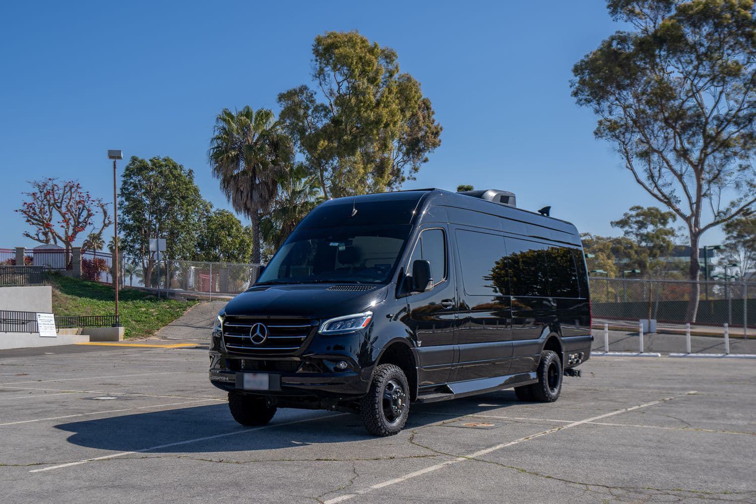 Black Mercedes van in a parking lot.