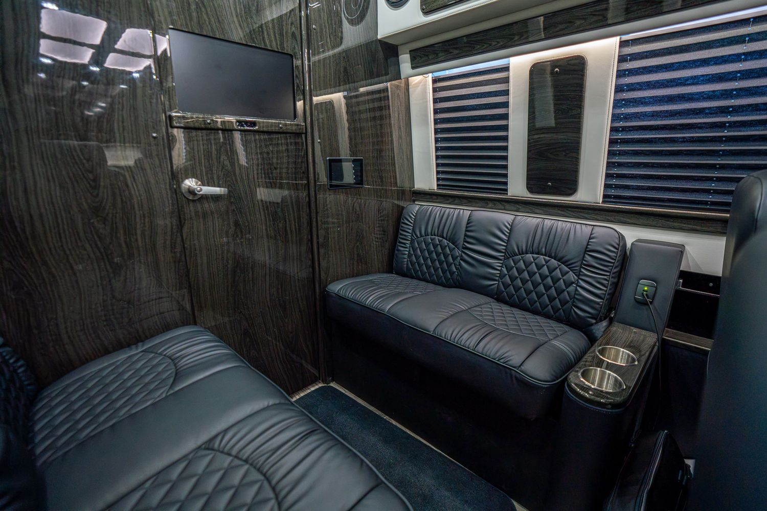 Black van parked near modern buildings.